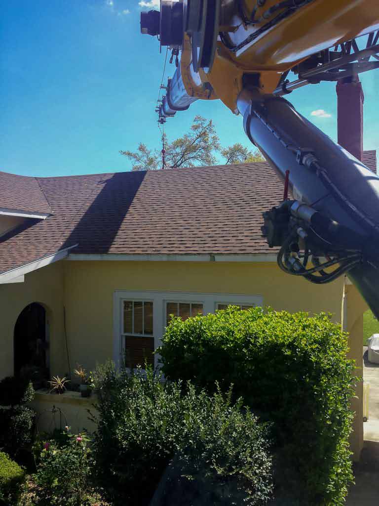 Crane lifting over house