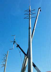Crane placing high electric pole