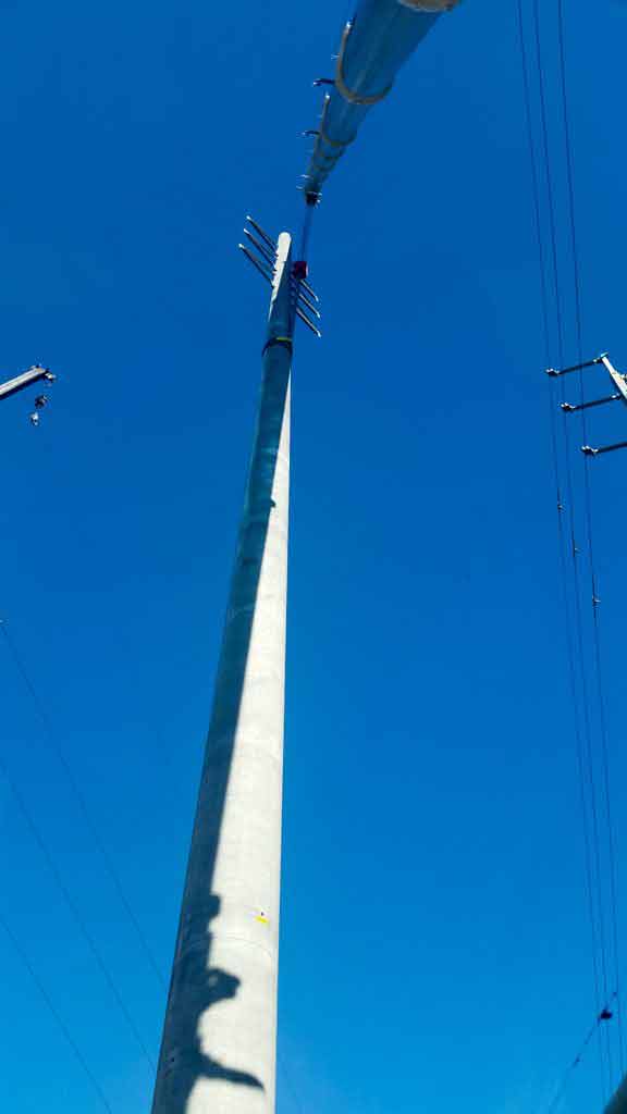 Crane placing high electric pole